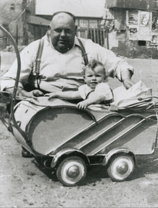 876455 Portret van caféhouder Marinus Johannes de Winter ('Dikke Dries', 1901-1952), bij een kinderwagen met kleinzoon ...